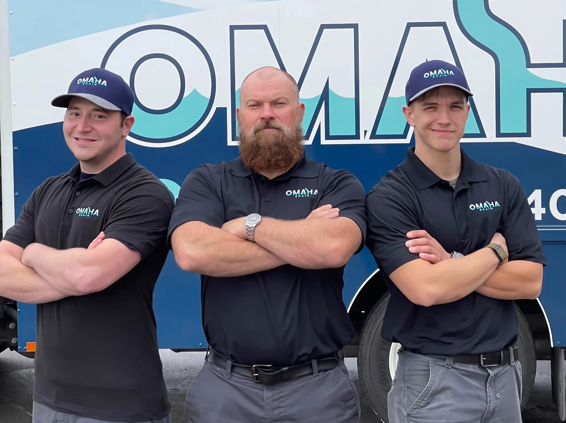 Omaha Drain technicians standing in front of a branded Omaha Drain service van in Omaha