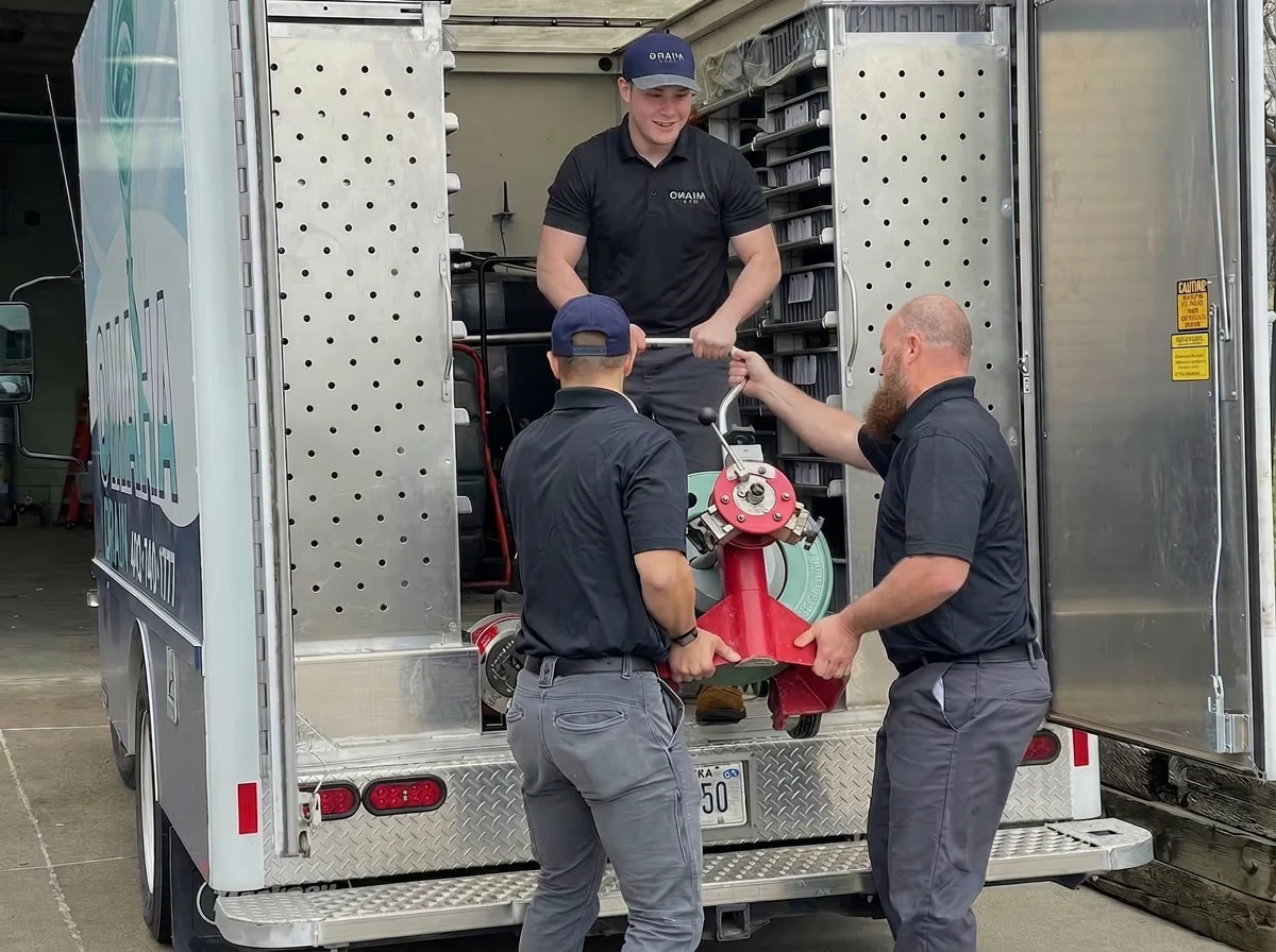 Omaha Drain technicians unloading a drain cleaning machine from their service truck
